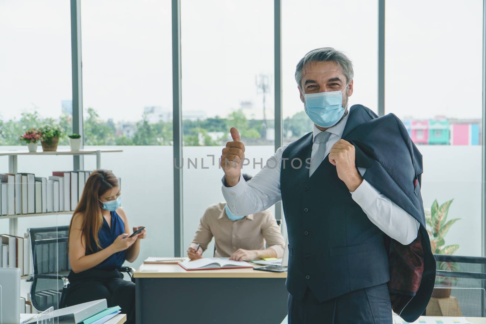 Business people wear a protective mask to work together in the company office. social distancing is the new normal. The concept of preventing the spread of coronavirus or COVID-19