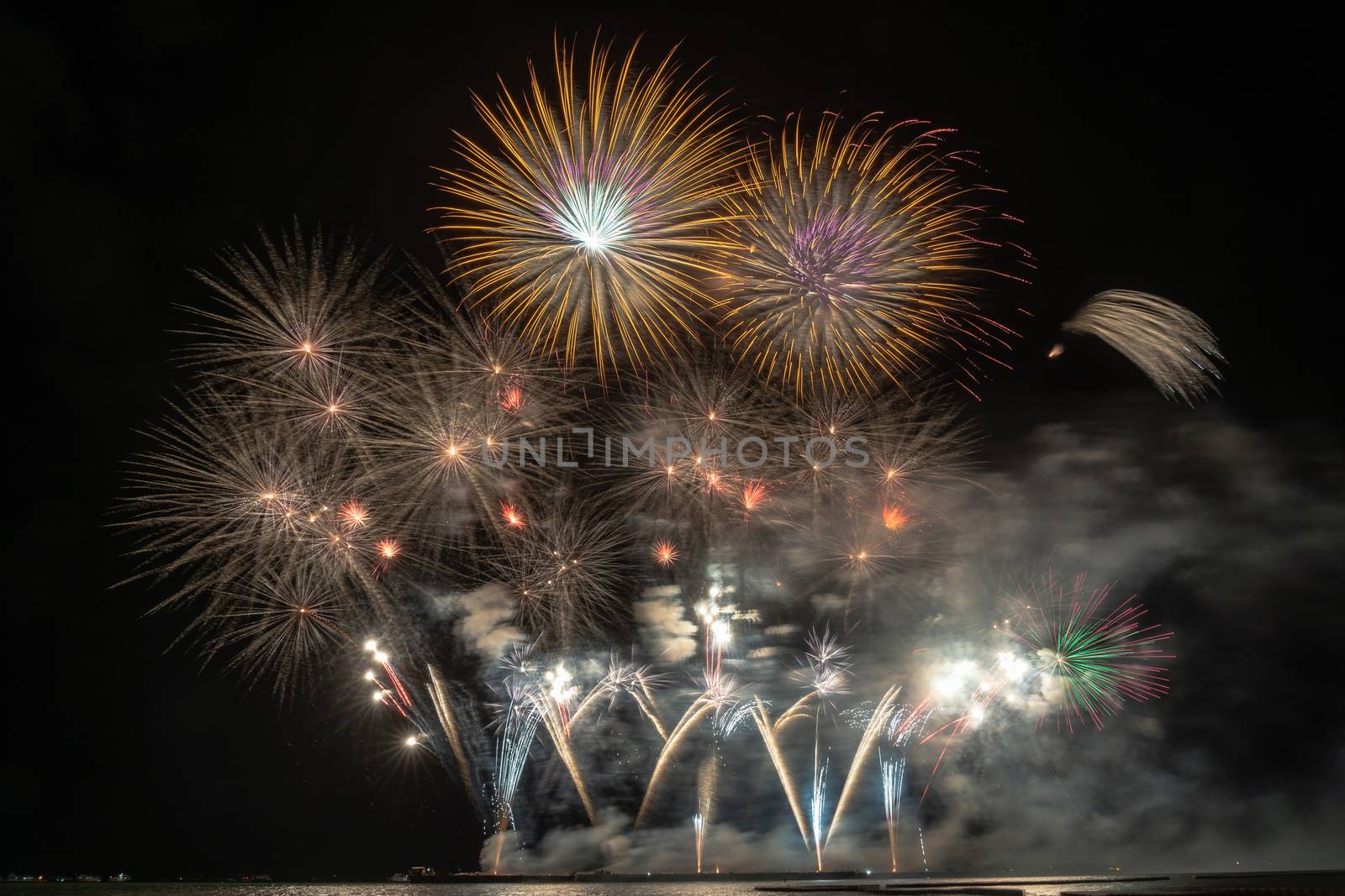 Fantastic Multicolor Firework exploding for Celebration from the big boat over the sea, celebration and happy new year and merry christmas concept
