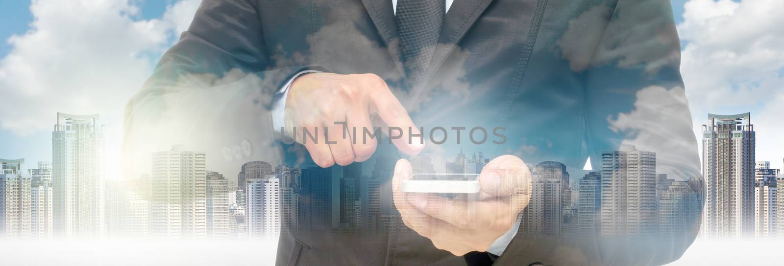 Double exposure of businessman using the smart phone on cityscap by Tzido
