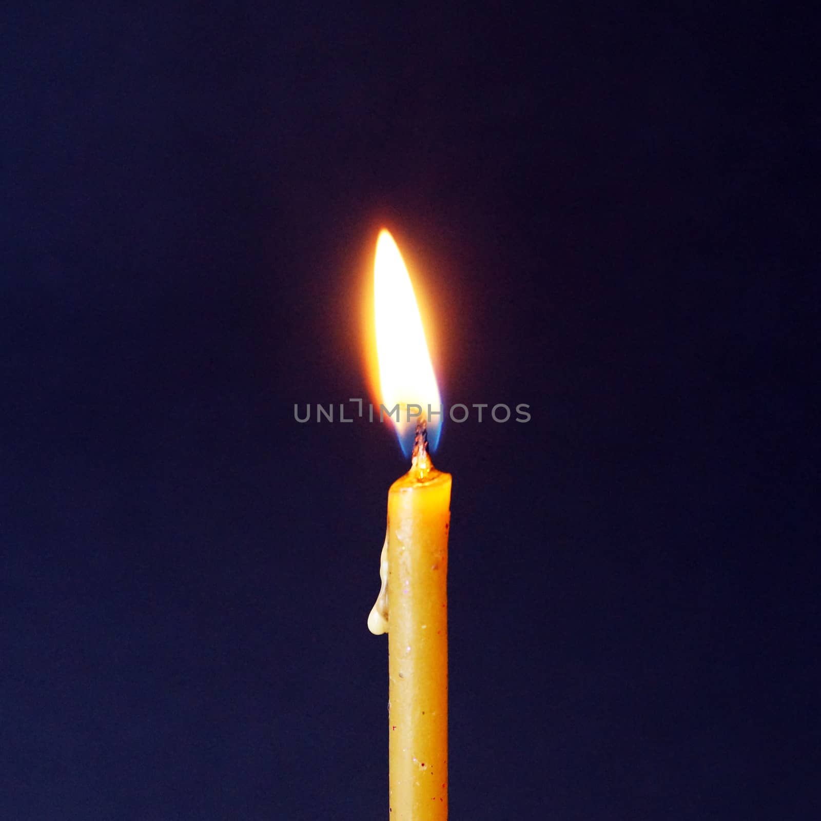 burning wax candle close up on dark background by Annado