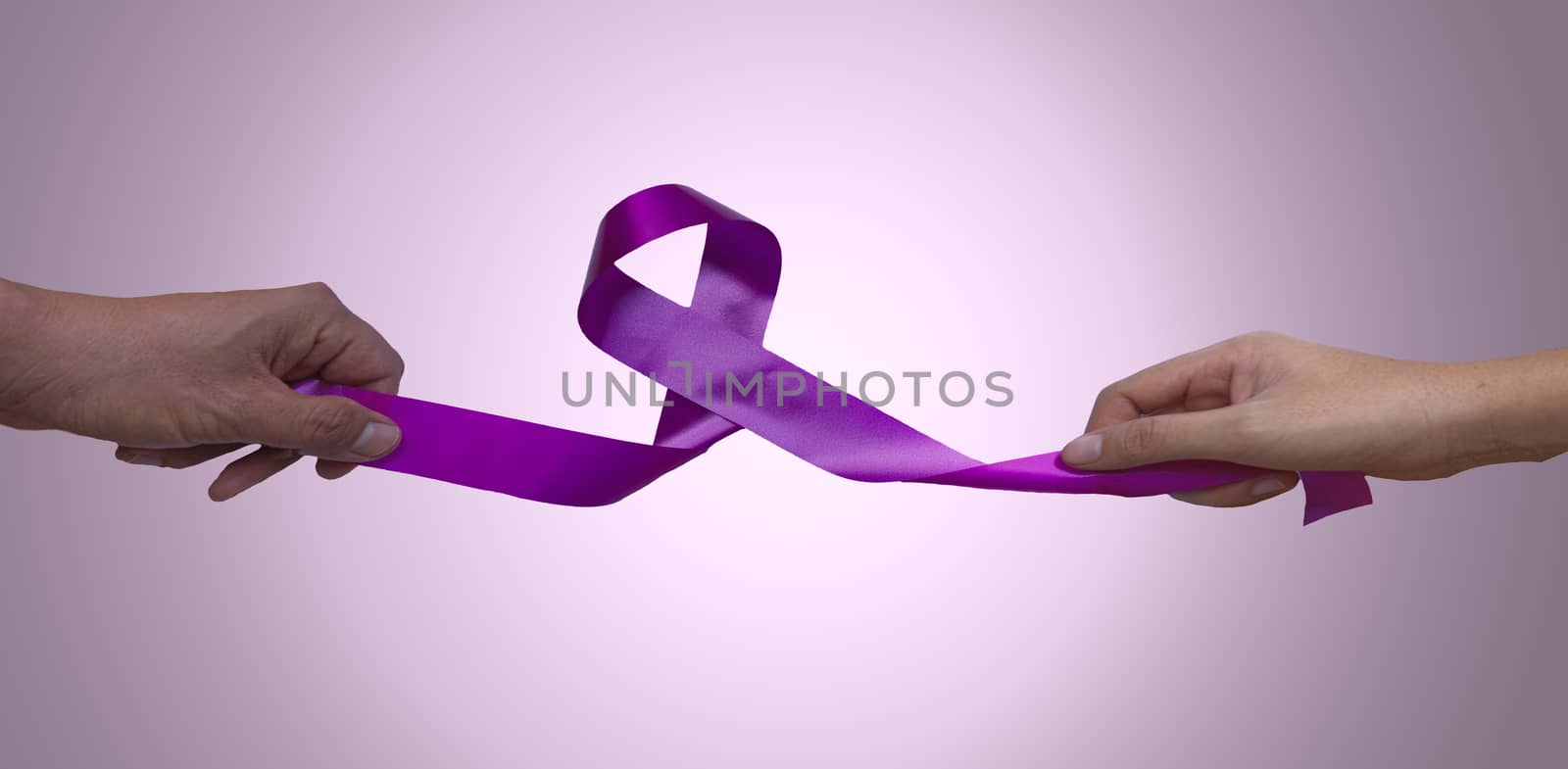 Female hands and men hand pulling pink ribbons expressing breast cancer awareness day concept isolated on pink background select focus ribbon. by noppha80
