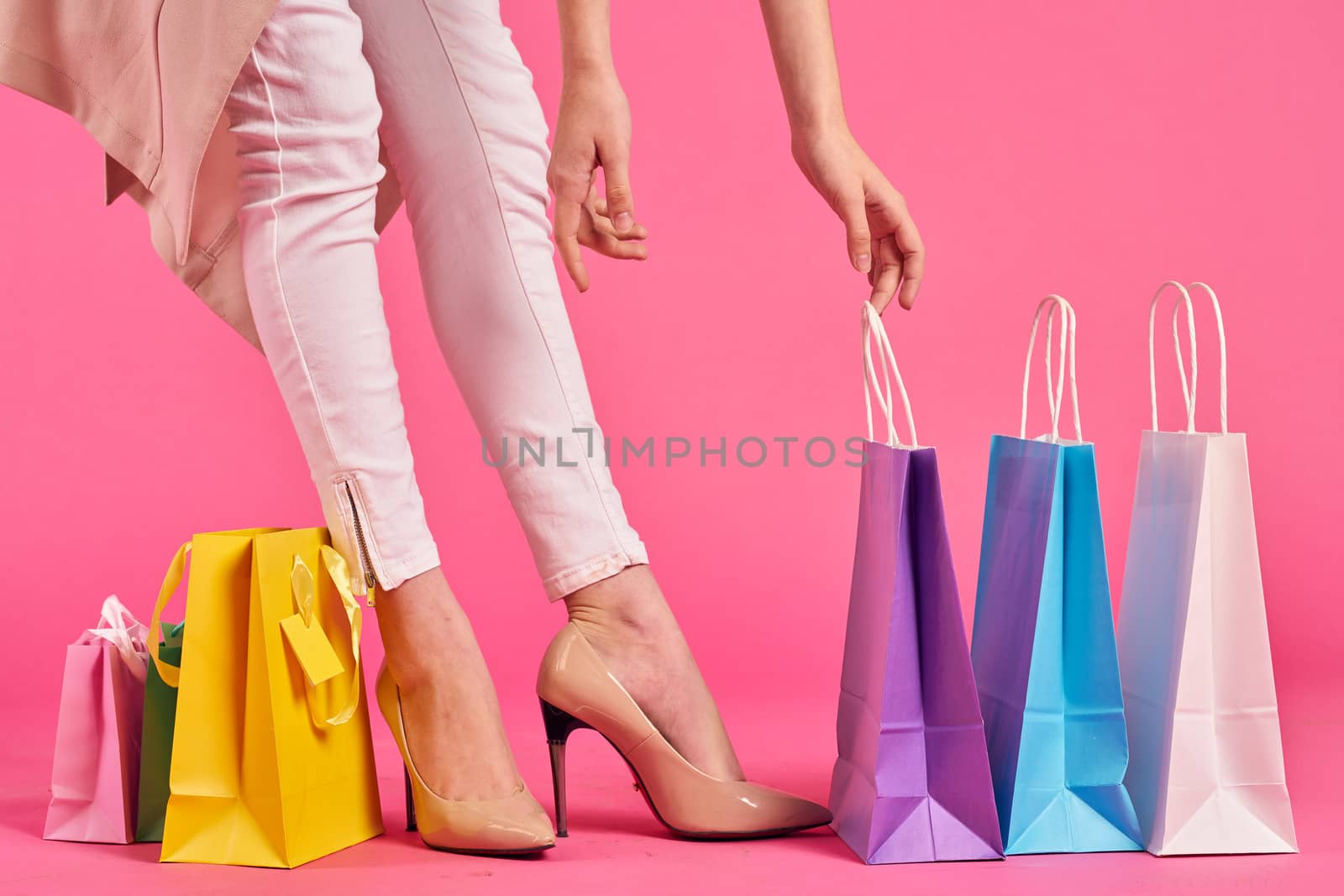 shopping bags female feet in shoes Shopaholic pink background. High quality photo