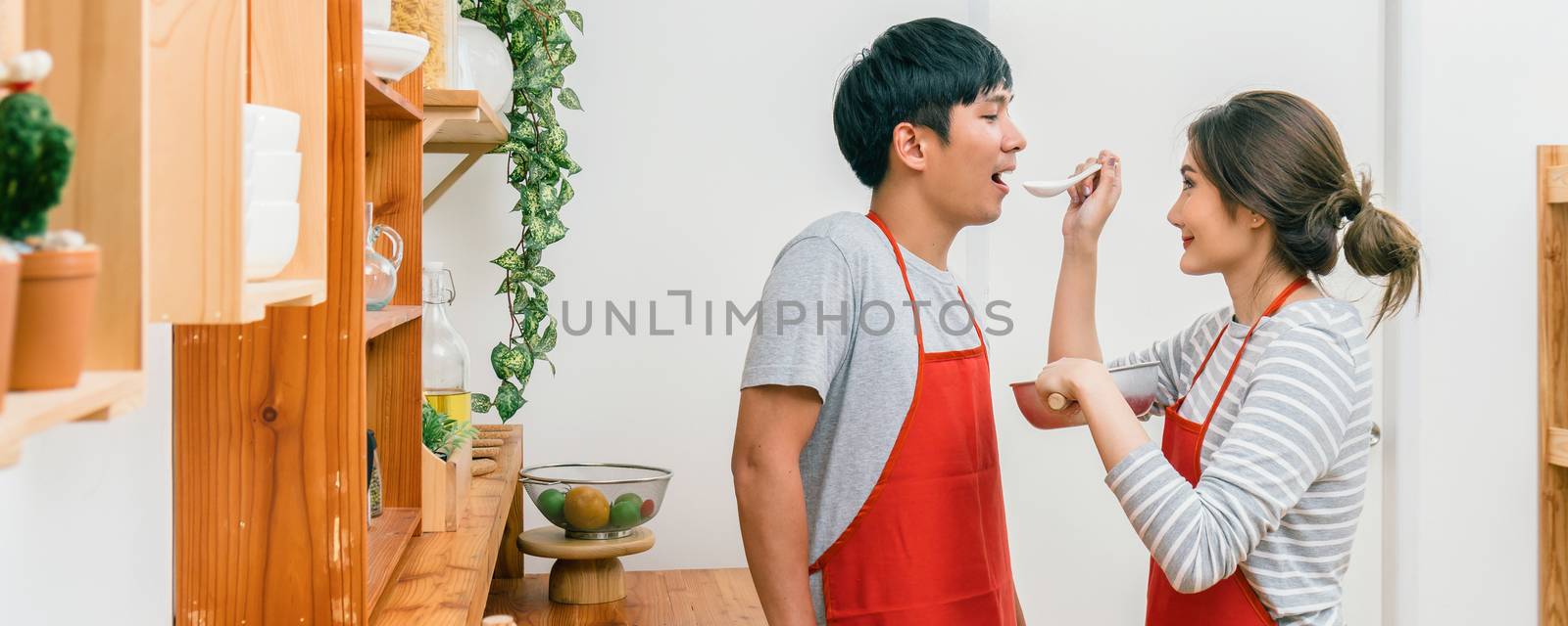 Banner and cover scene of Happy Asian Lover or couple cooking in happiness action in the kitchen room at the modern house, Couple and life style, kitchen and food concept.