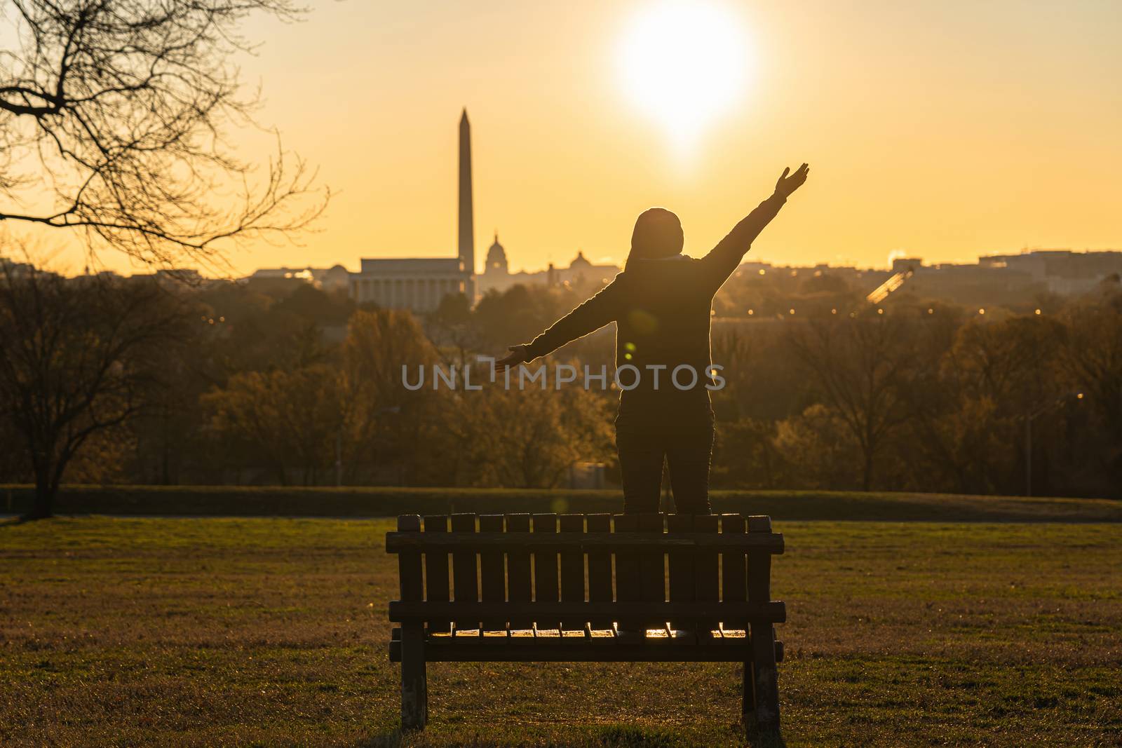 Back side of asian woman standing and Lifting hands for success by Tzido