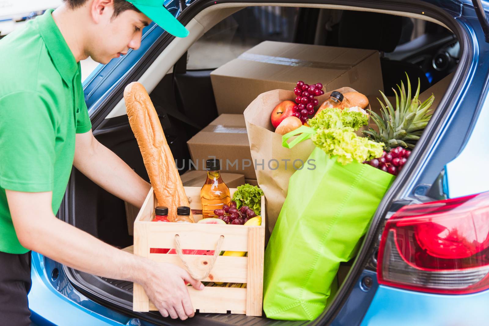 Asian delivery man grocery prepare service giving fresh vegetables food and fruit full in wooden basket on back car to send woman customer at door home after pandemic coronavirus, Back to new normal