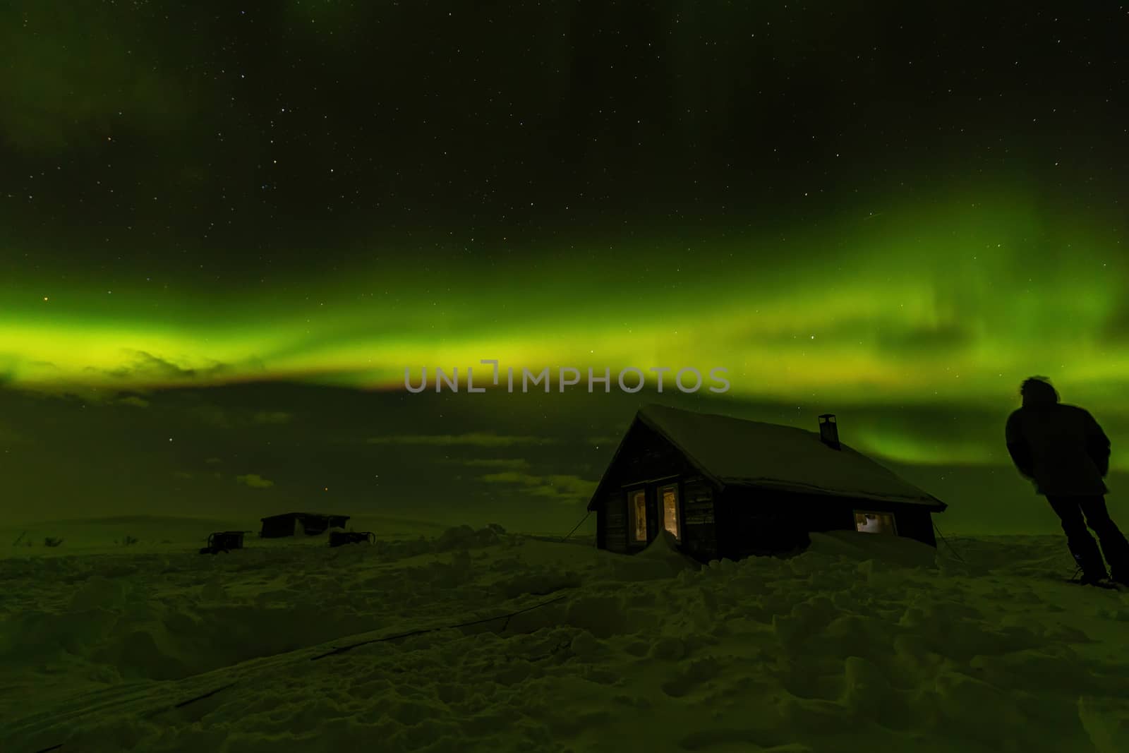 Northern lights Aurora Borealis over snowed-in cottage in Lapland, Sweden by COffe