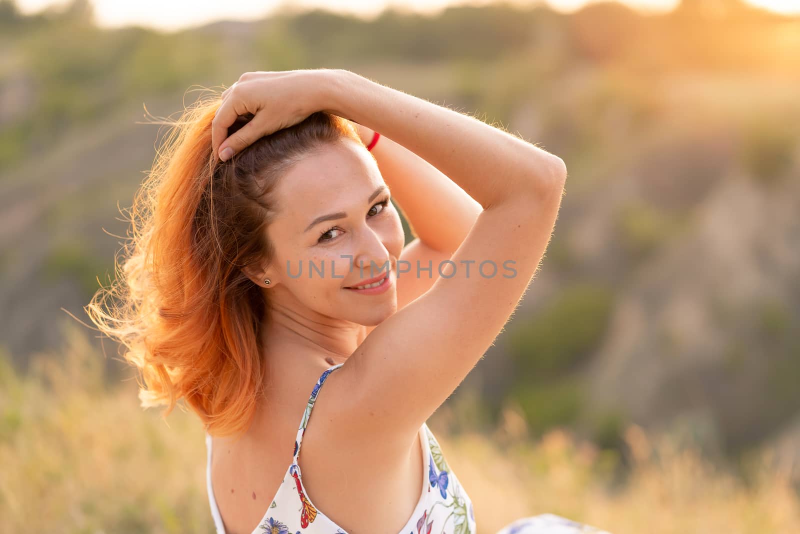 Tender beautiful red-haired girl enjoys the sunset in a field wi by Try_my_best