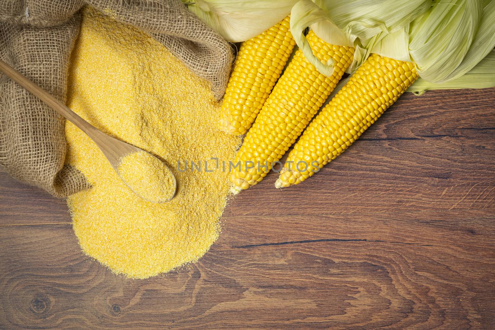 Ripe young sweet corn cob spoon and cornmeal from above by Robertobinetti70