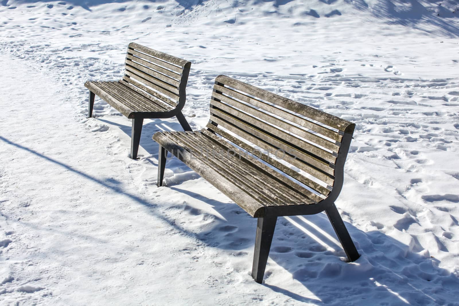 Two empty benches on snow covered ground by Ivanko