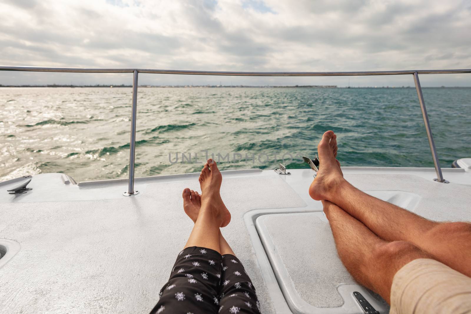 Yacht boat lifestyle couple relaxing on cruise ship in Hawaii holiday . Two tourists feet relax getaway enjoying summer vacation by Maridav