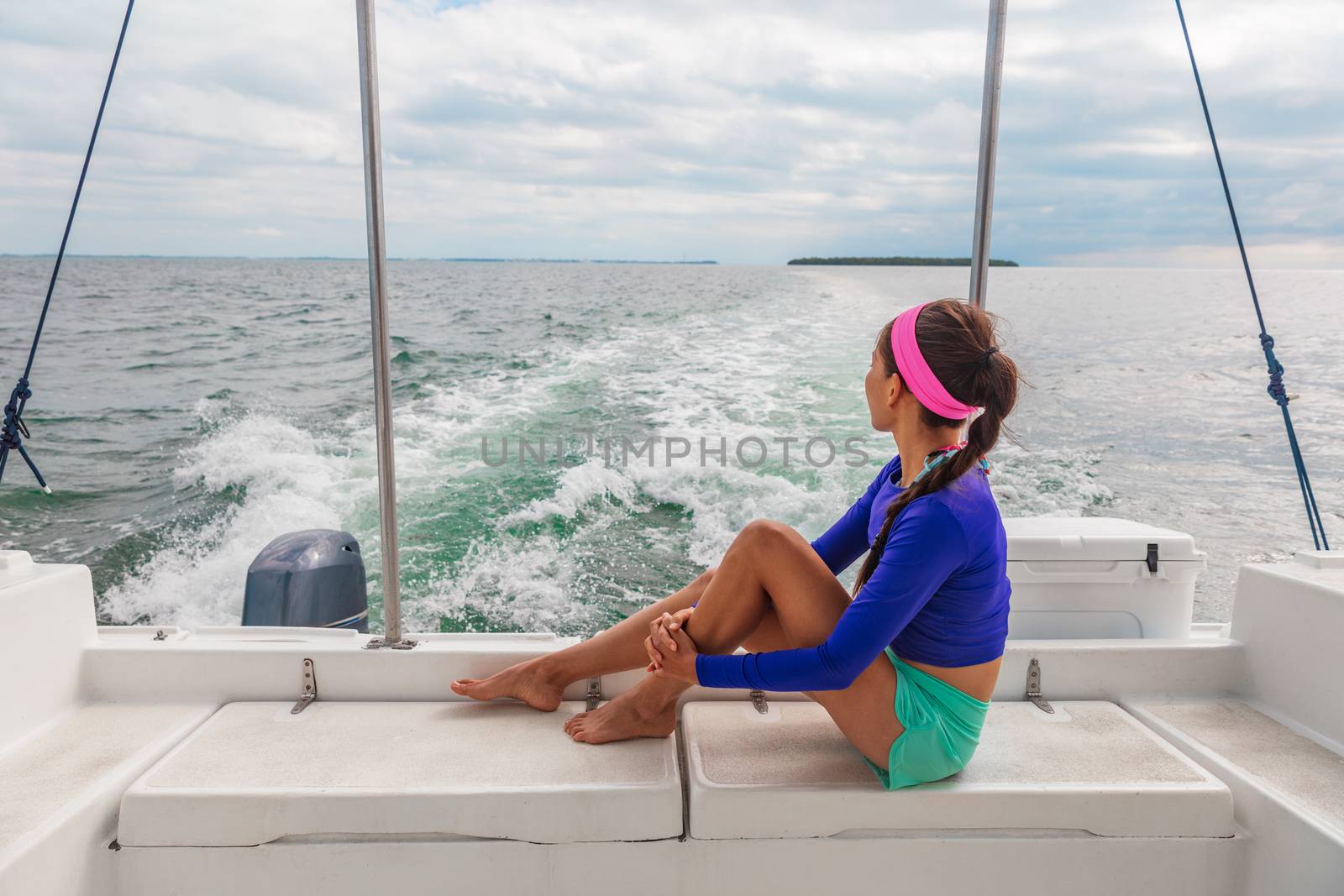 Travel boat excursion tour woman tourist relaxing on deck of motorboat catamaran summer vacation.