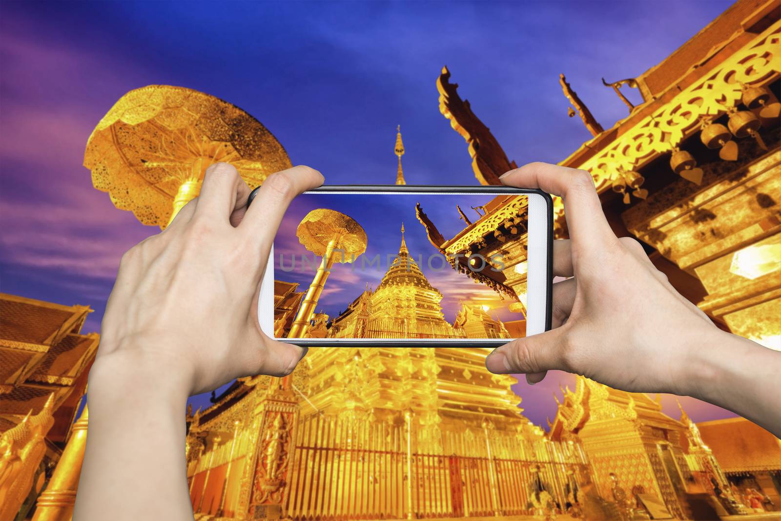 Woman Taking pictures on mobile smart phone showing Night view of Wat Phra That Doi Suthep, Chiang Mai, Popular historical temple in Thailand.