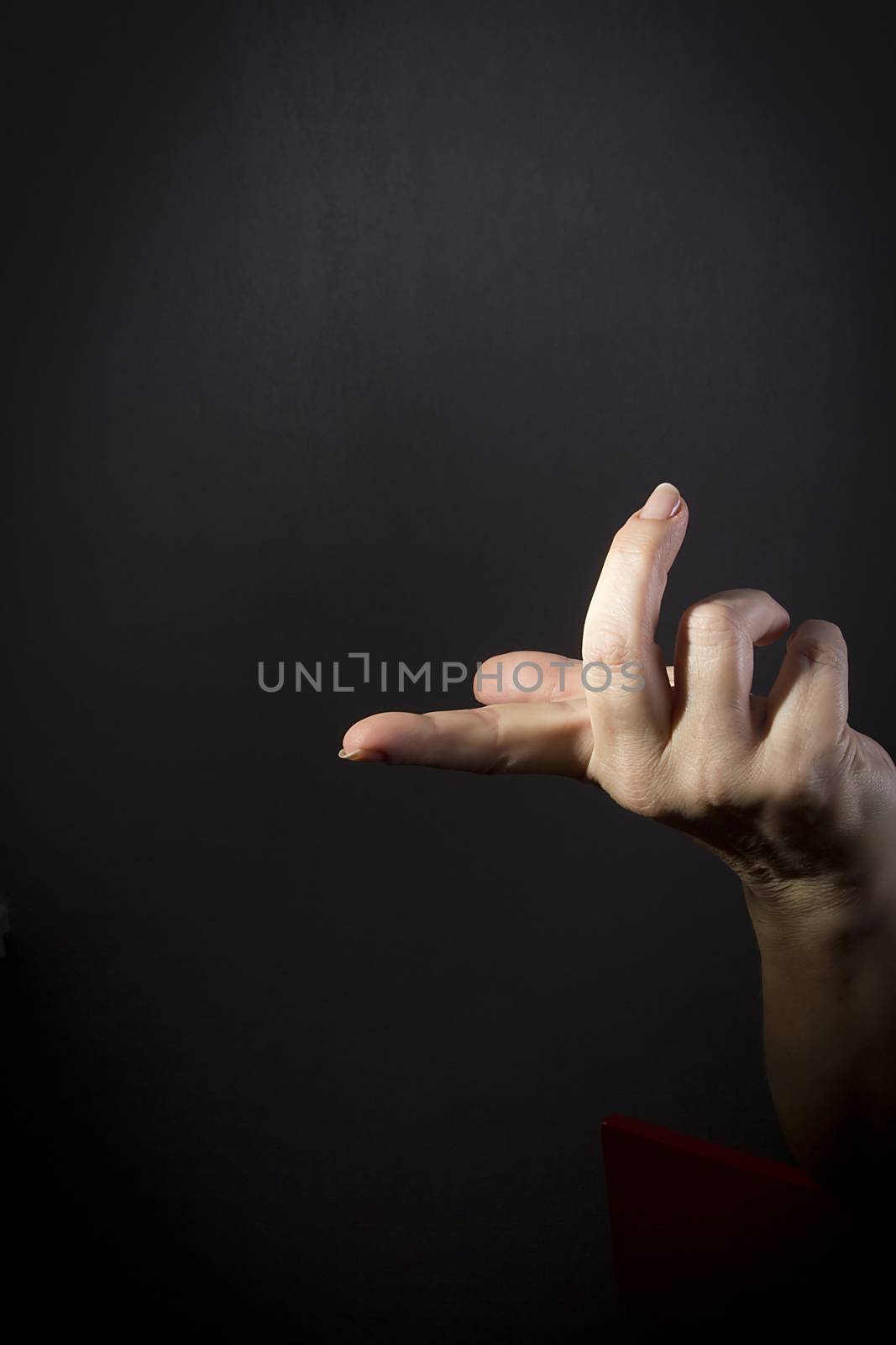 Female hand with protruding forefinger on black background