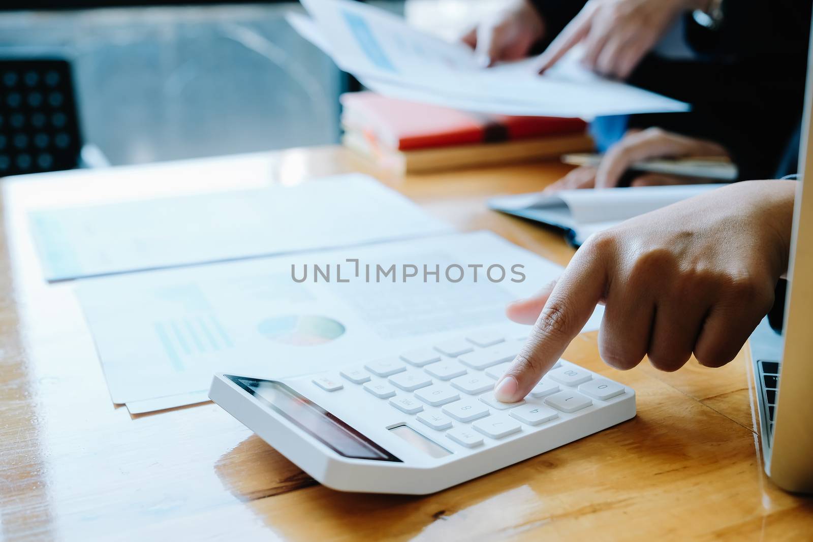 Close up Businessman and partner using calculator and laptop for calaulating finance, tax, accounting, statistics and analytic research concept.