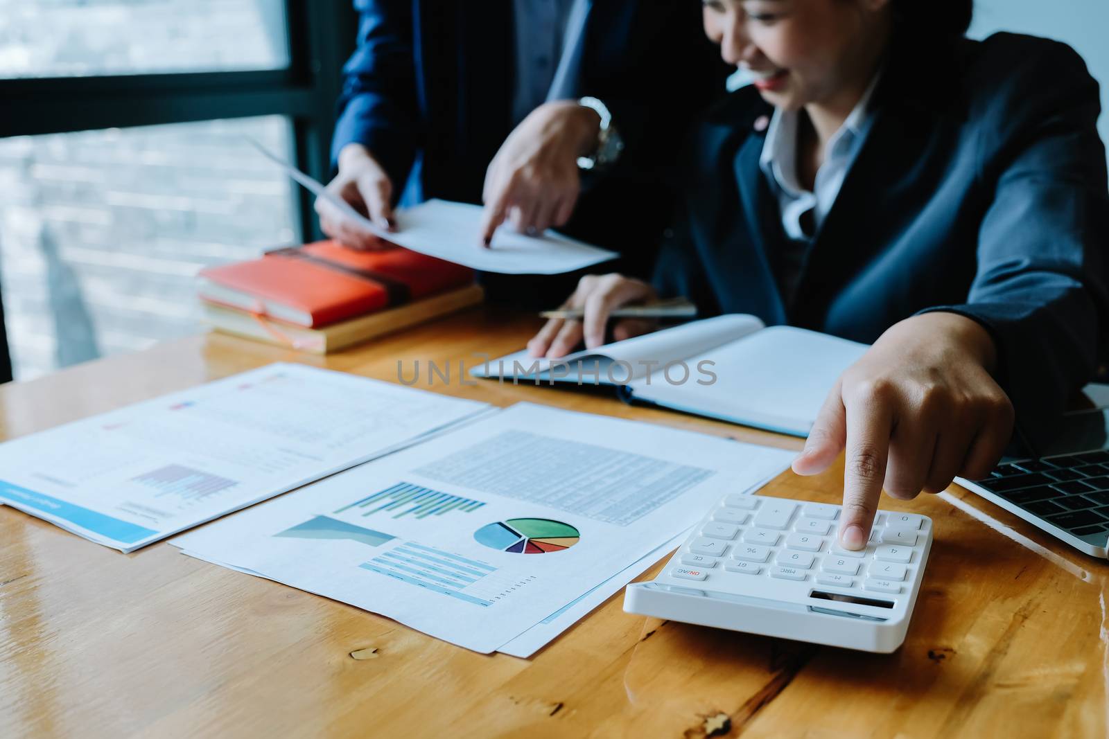 Close up Businessman and partner using calculator and laptop for calculating finance, tax, accounting, statistics and analytic research concept.