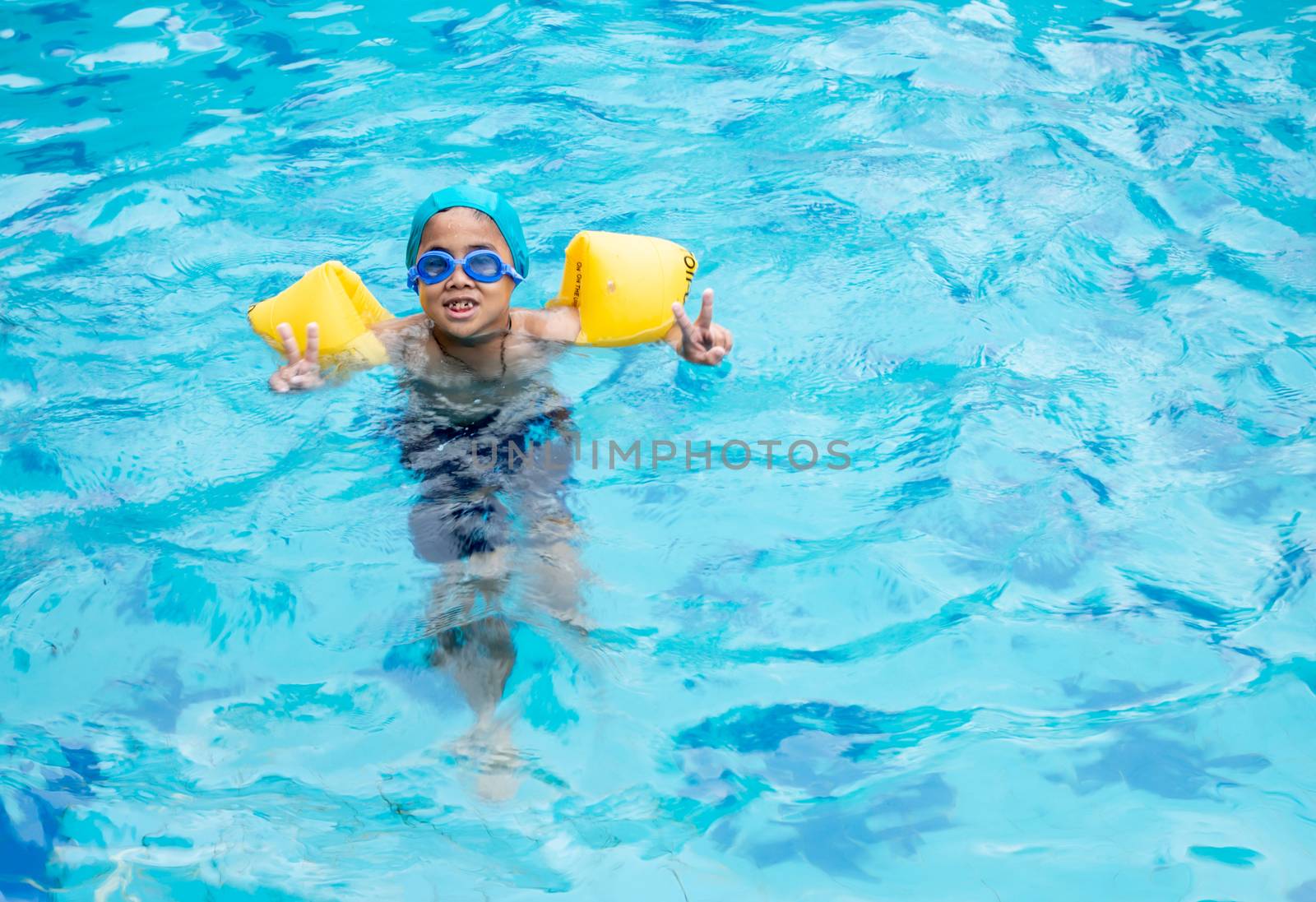 Boy practicing swimming in the pool by Unimages2527