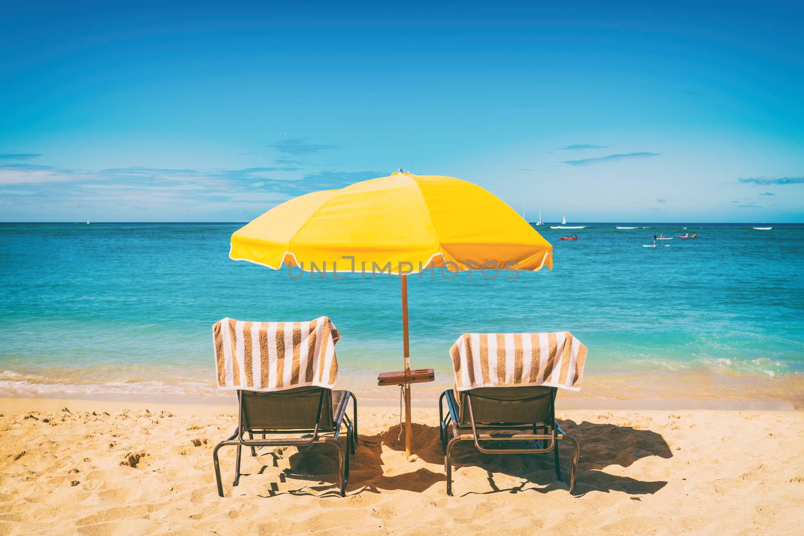 Beach holiday lounging chairs under sun umbrella vacation background. Summer tropical travel destination.