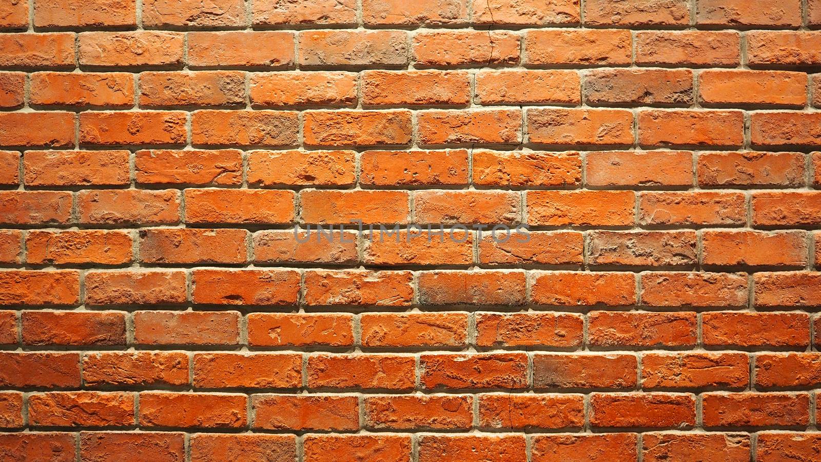 Red brick wall and old dirty rough surface texture close-up.