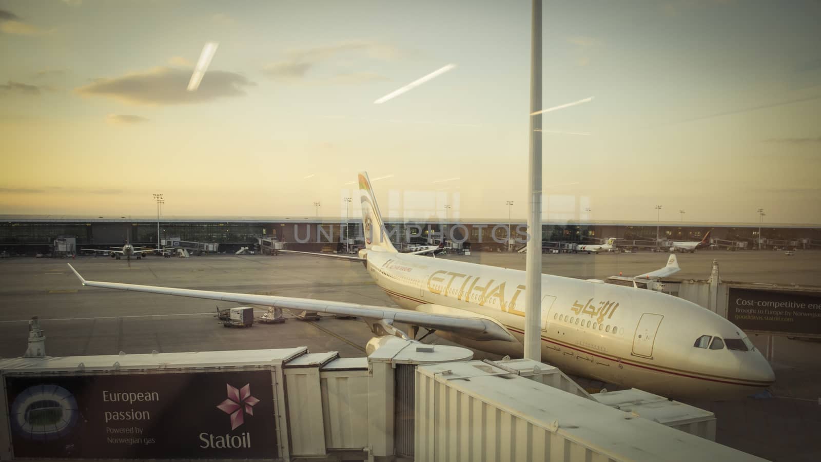 Etihad Airways airplane parked at the gates of the airport uring sunset by kb79