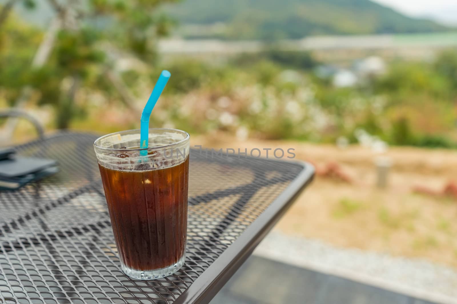 Cup of iced coffee with straw on table