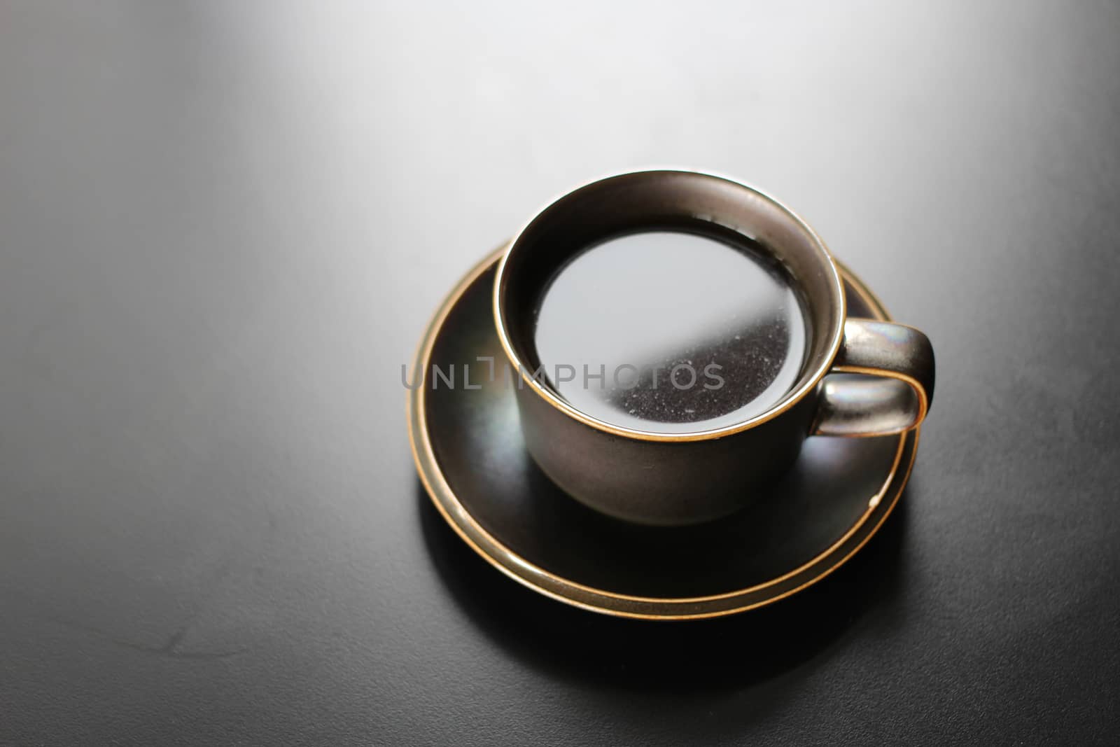 Cup of coffee on black background by uphotopia