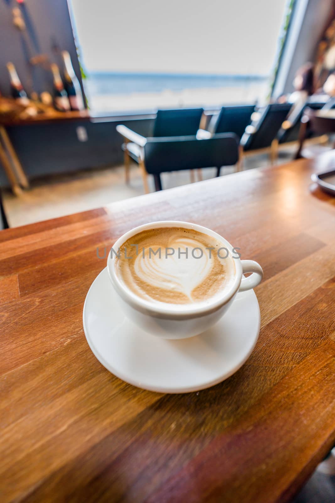 Cup of coffee with latte art on wooden table