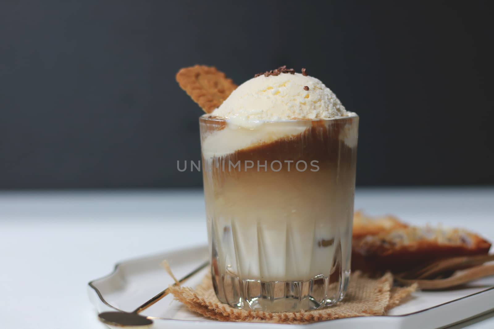 Cookie and cup of iced coffee on table by uphotopia