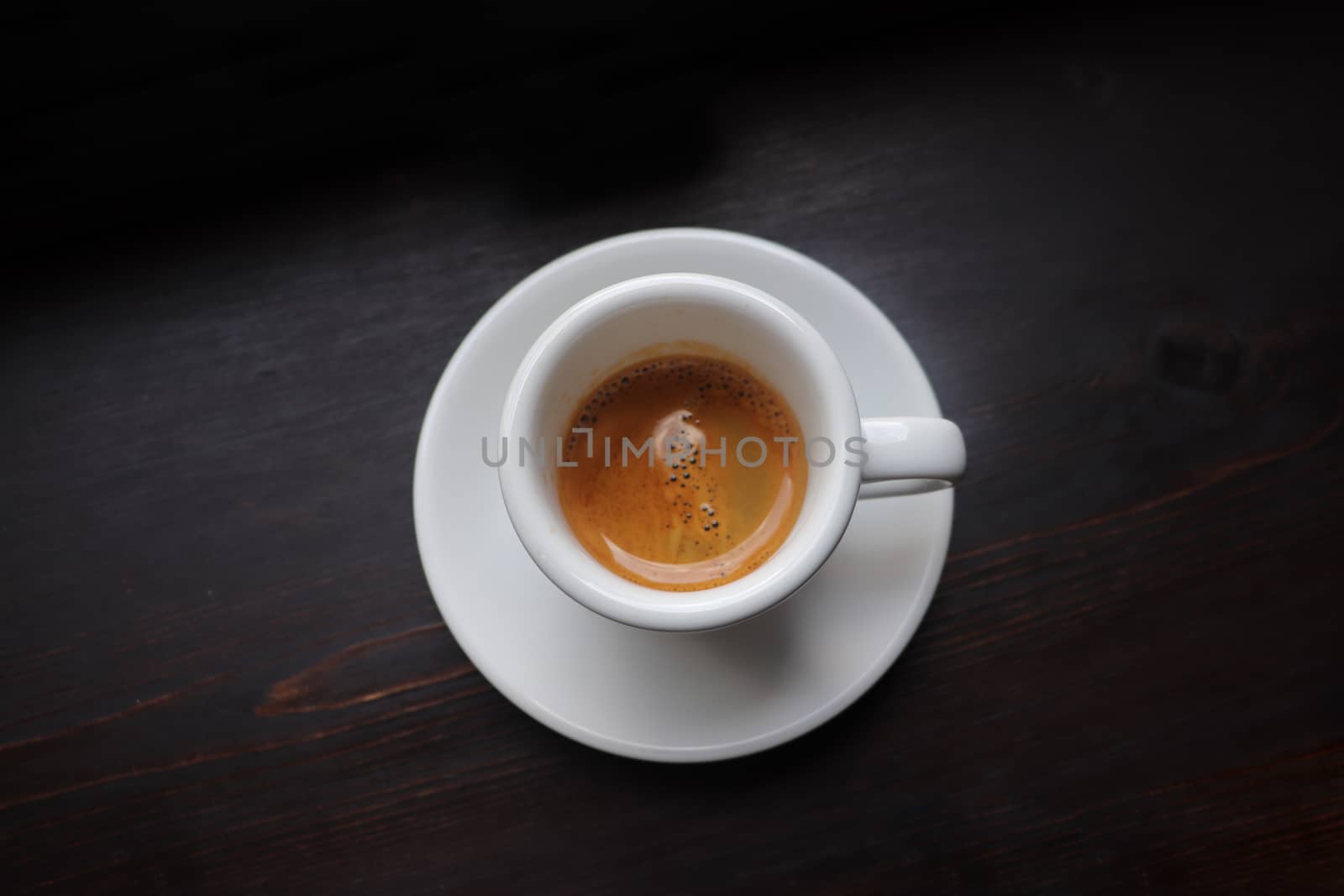 Cup of coffee with latte art on wooden background by uphotopia