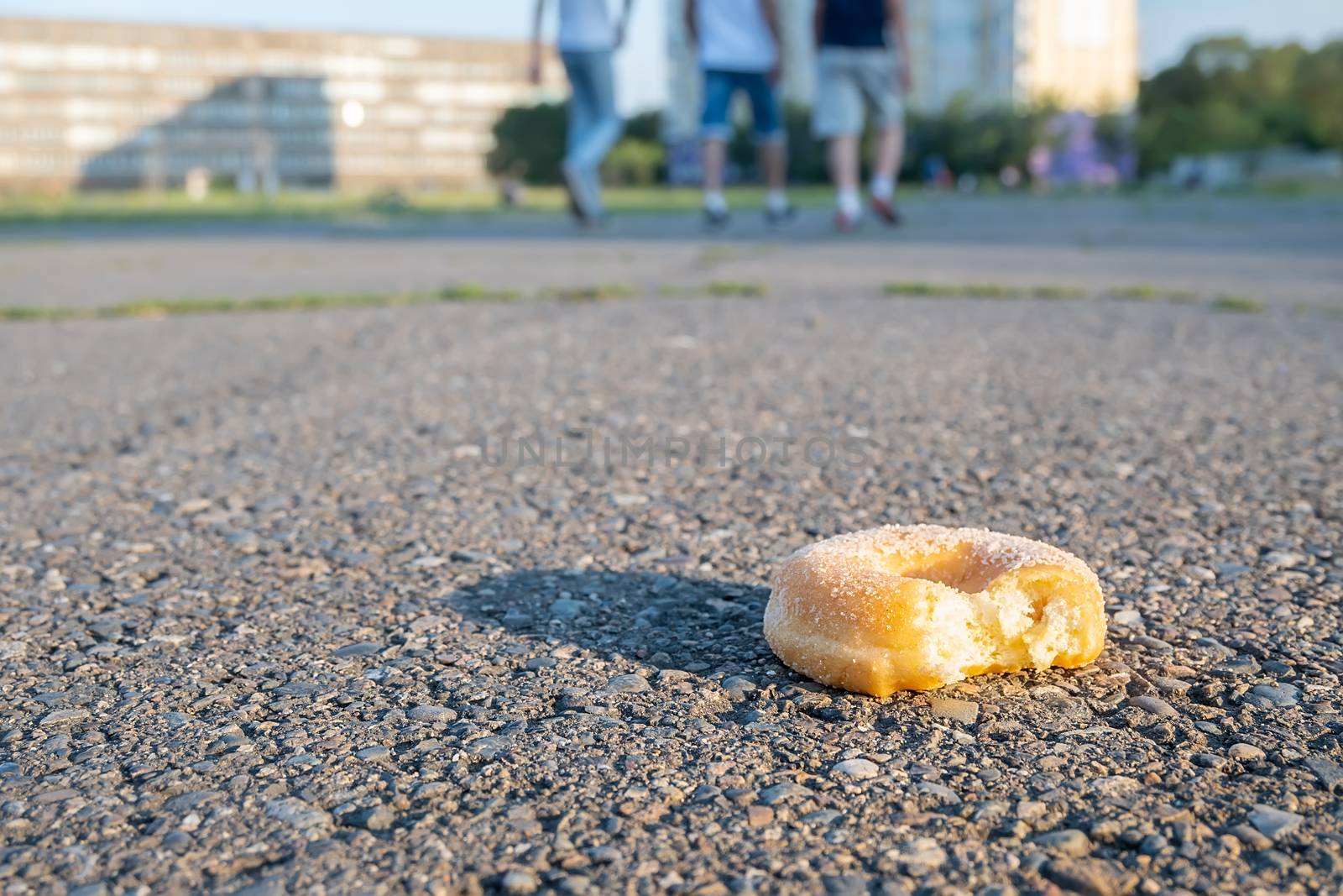 a nibbled doughnut, a bun, is lying on the track of the stadium by jk3030