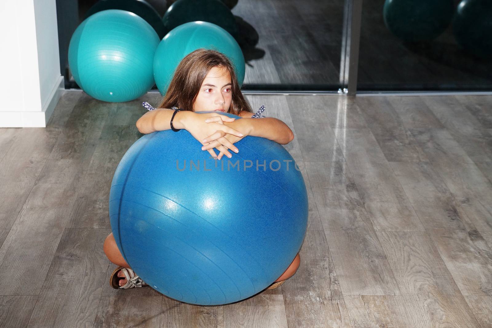 teenager girl with fitness ball in gym.