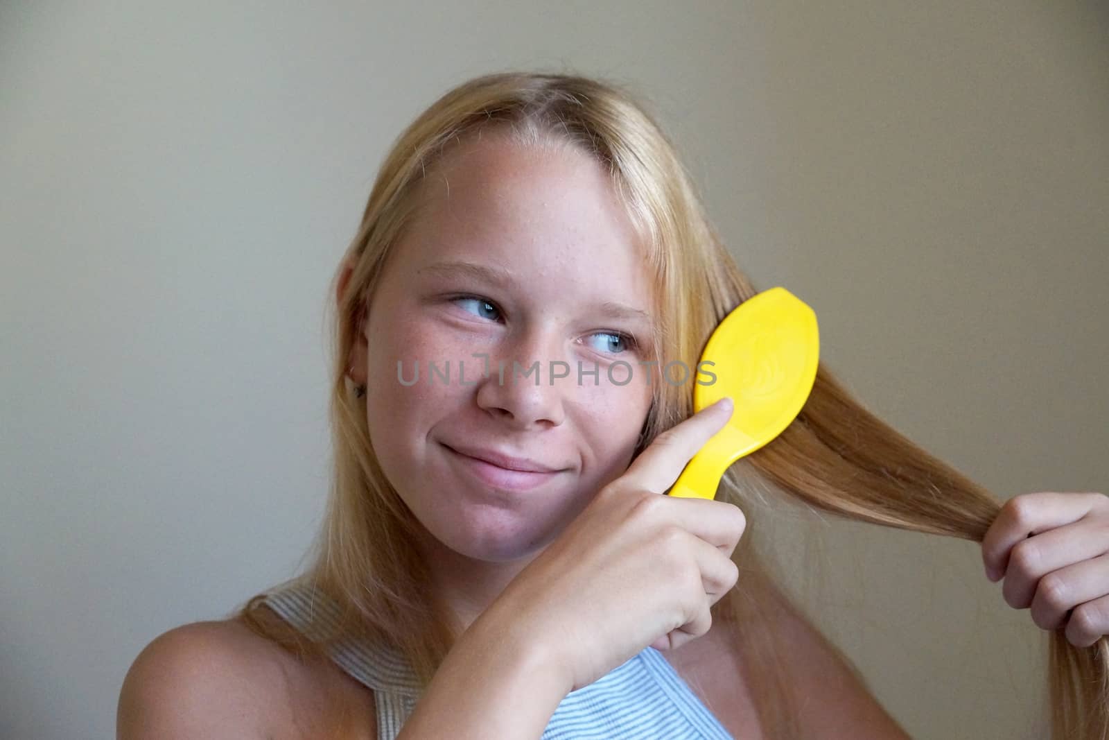 smiling girl combing her hair, portrait close up by Annado