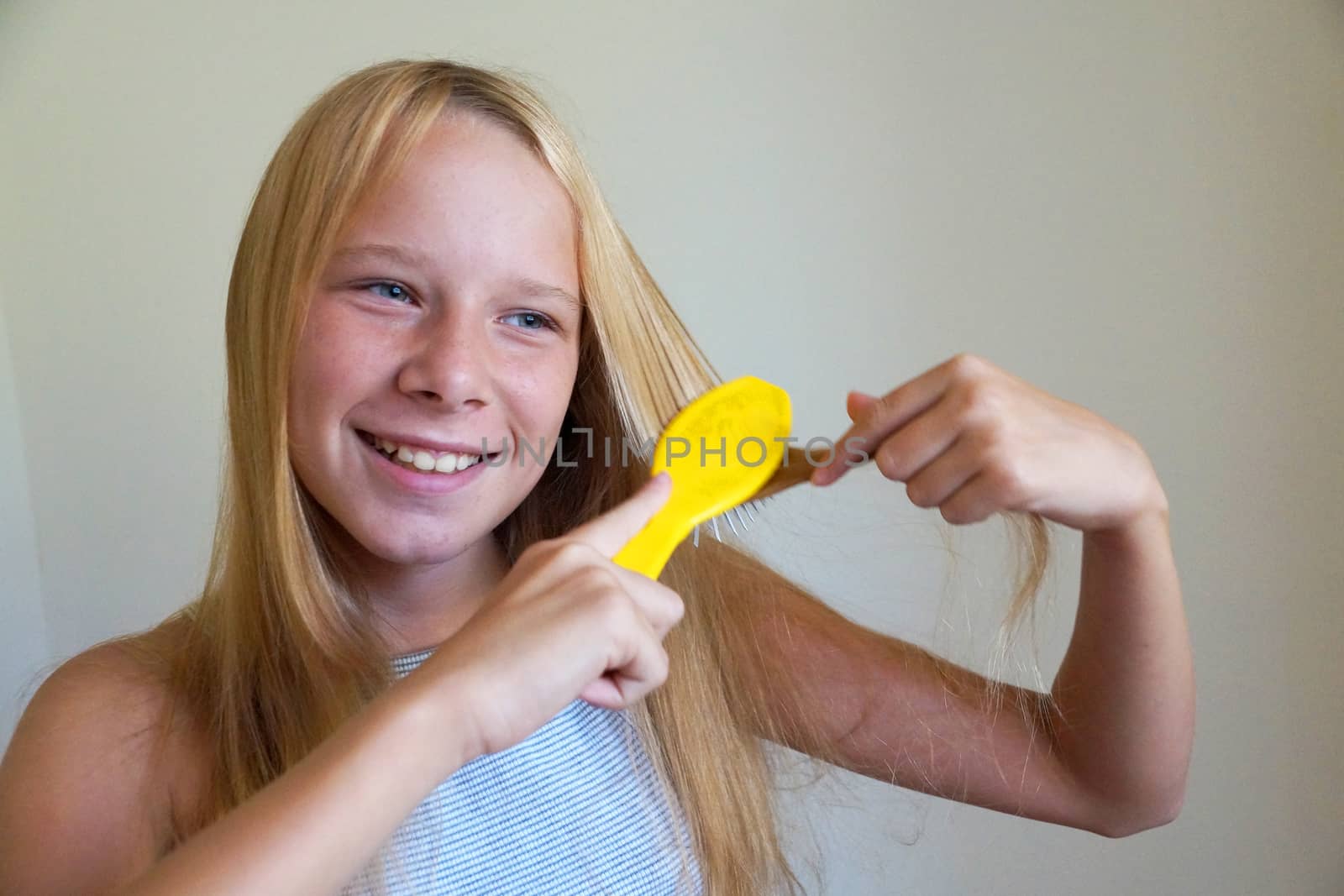 smiling girl combing her hair, portrait close up by Annado