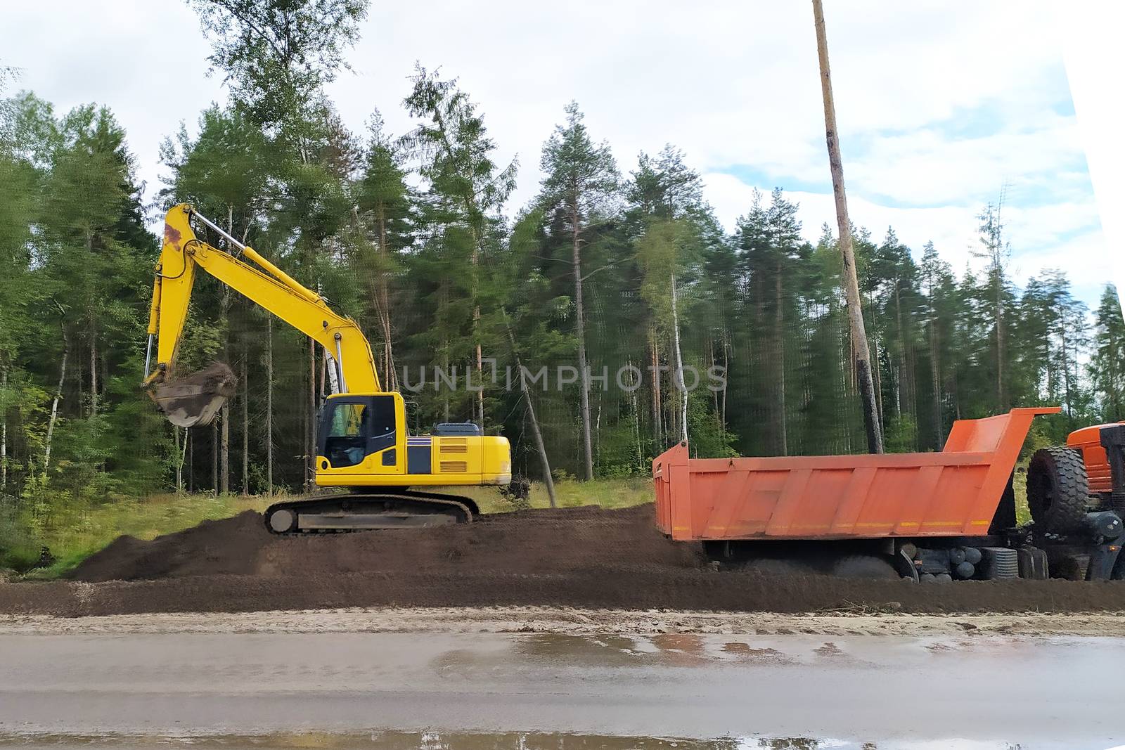 road works, bulldozer and dump truck widen the road.