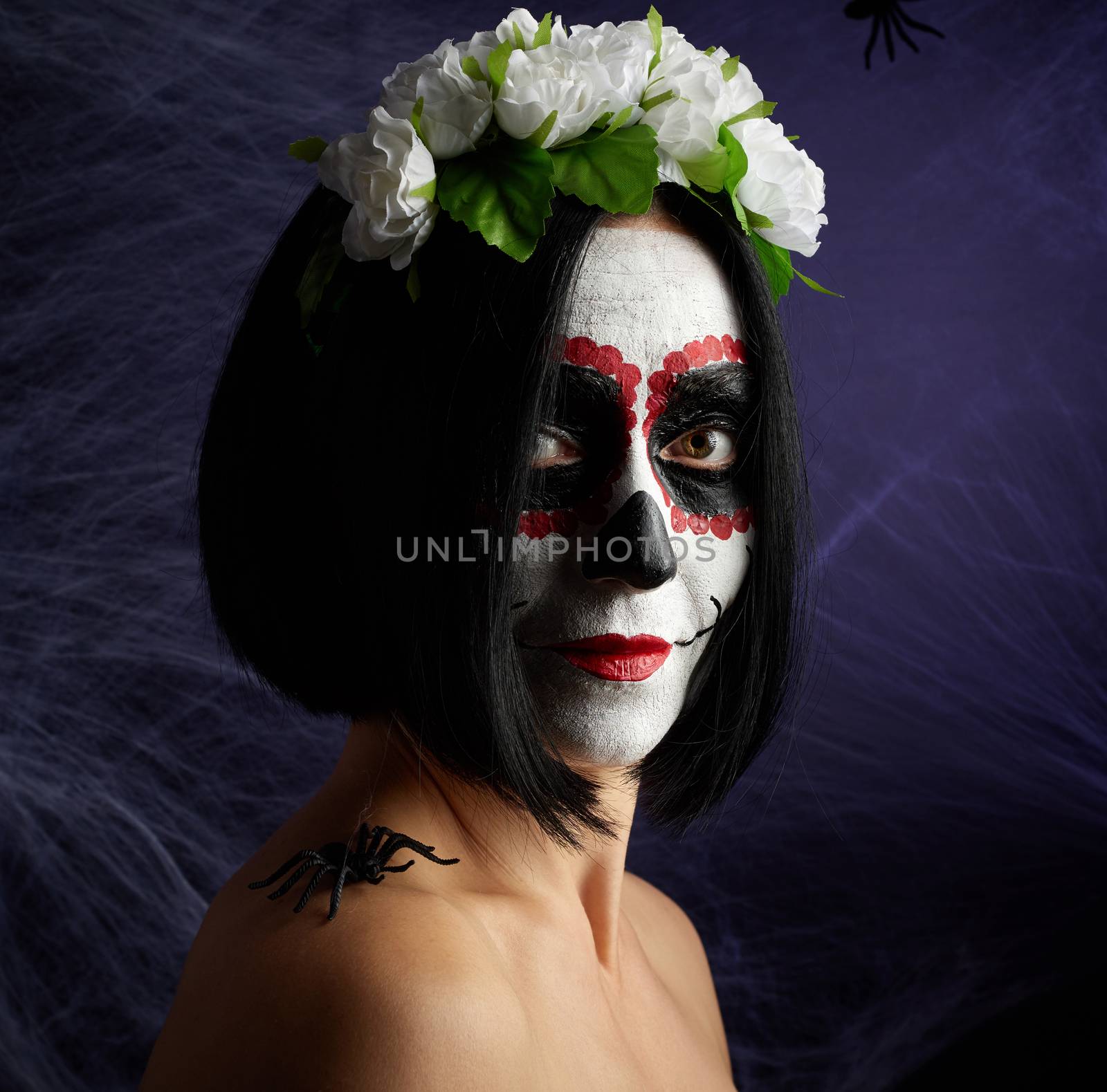woman of caucasian appearance is dressed in a wreath of multi-colored roses. Sugar skull Halloween Makeup, Calavera Catrina