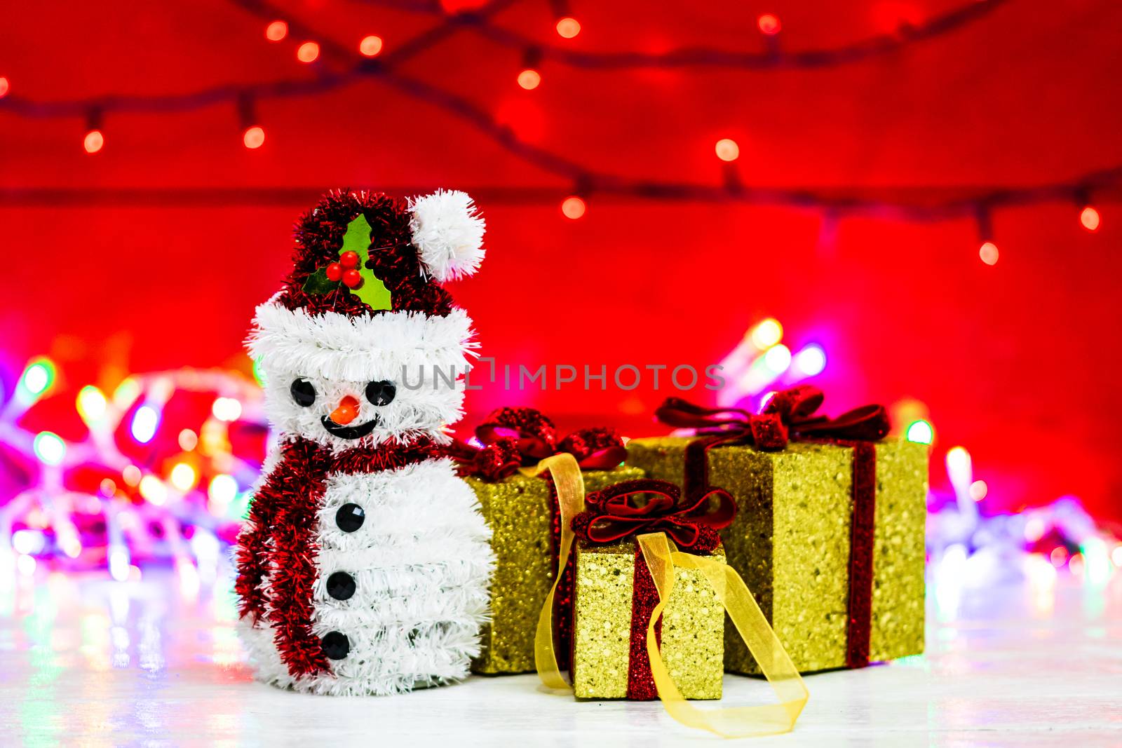 Snowman Christmas figurine near glittery gifts isolated on blurr by vladispas