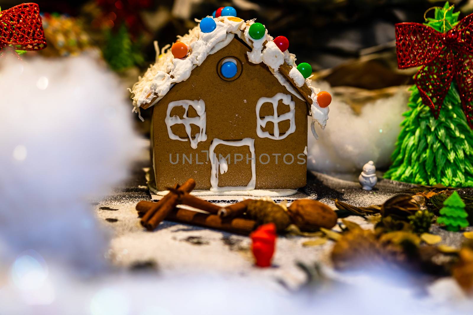 Colorful gingerbread house isolated on blurred background with Christmas decoration.