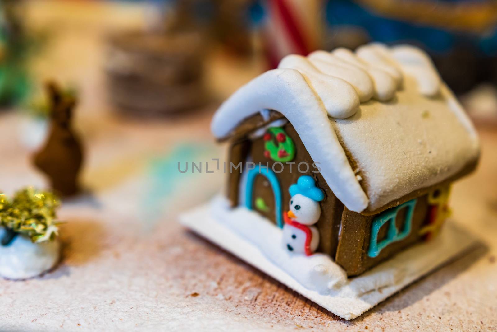 Colorful gingerbread house isolated on blurred background with Christmas decoration.