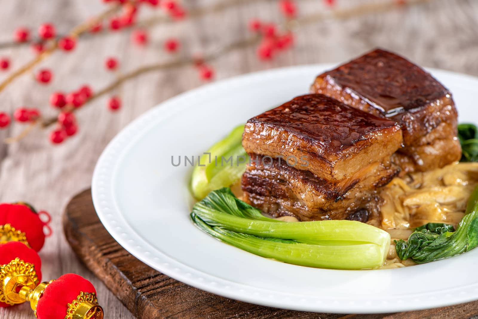 Dong Po Rou (Dongpo pork meat) in a beautiful blue plate with green broccoli vegetable, traditional festive food for Chinese new year cuisine meal, close up.