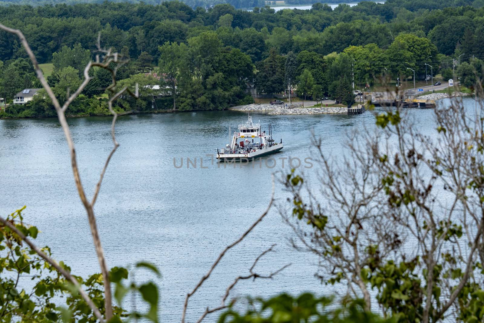 A ferry loaded with passenger cars sails from the island to the other side