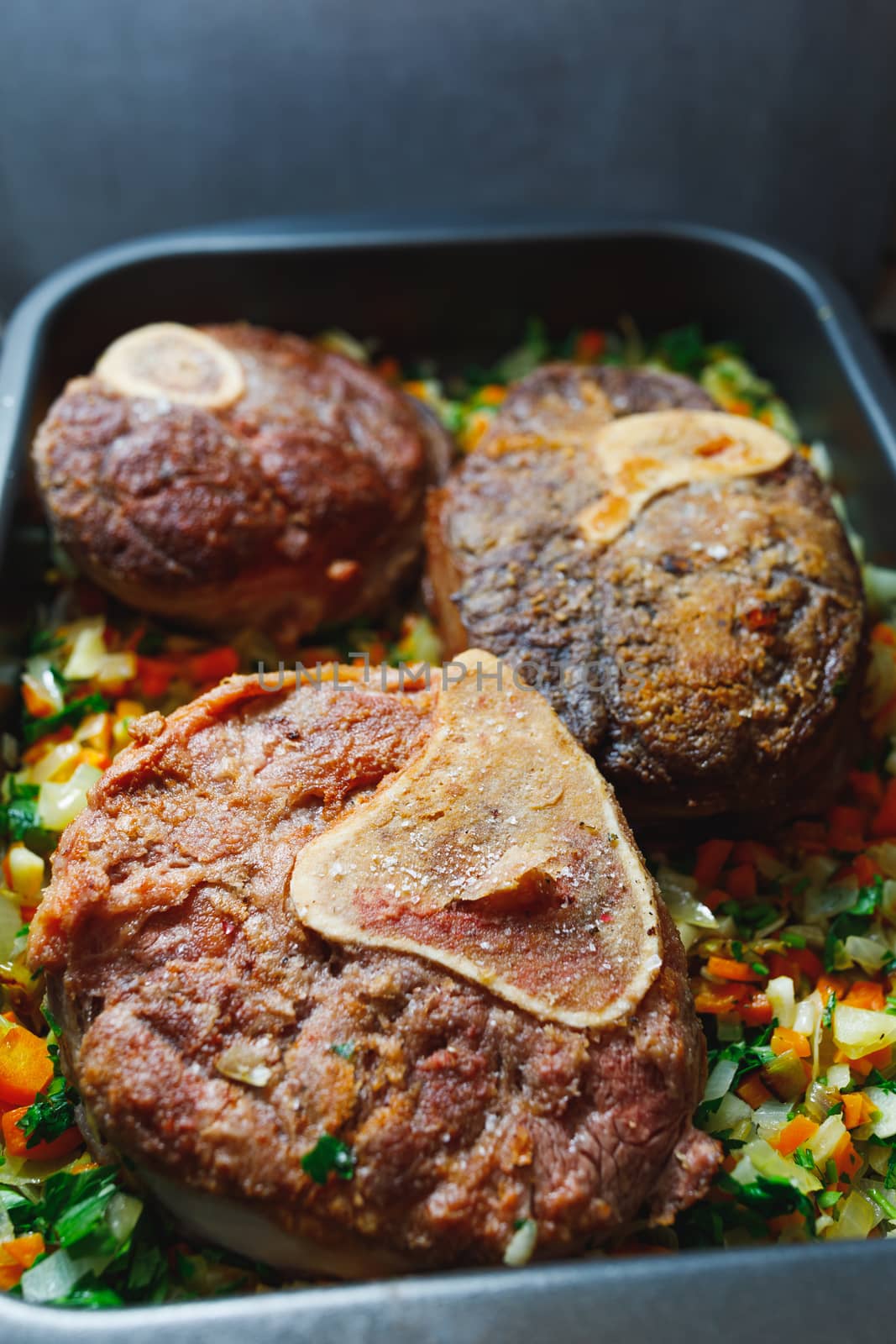 beef ossobuco meat on tray with crushed vegetables by nikkytok