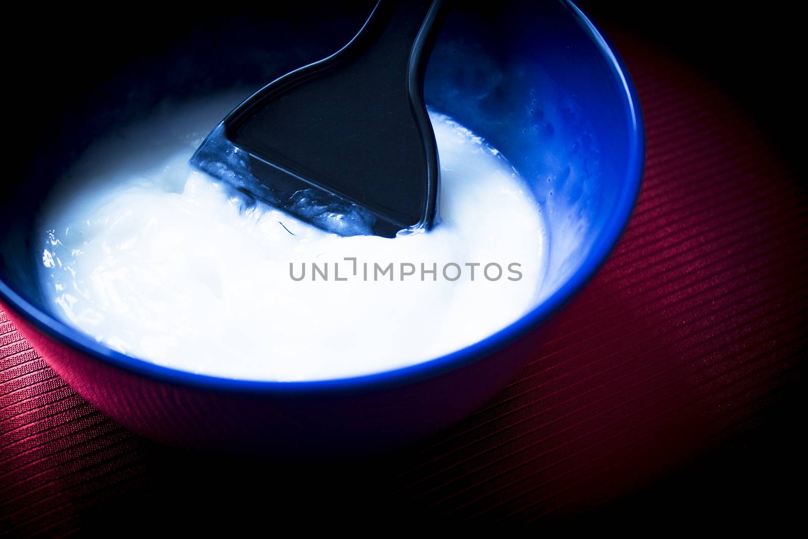 Blue bowl with mix to dye hair. Dye palette inside the mixing bowl