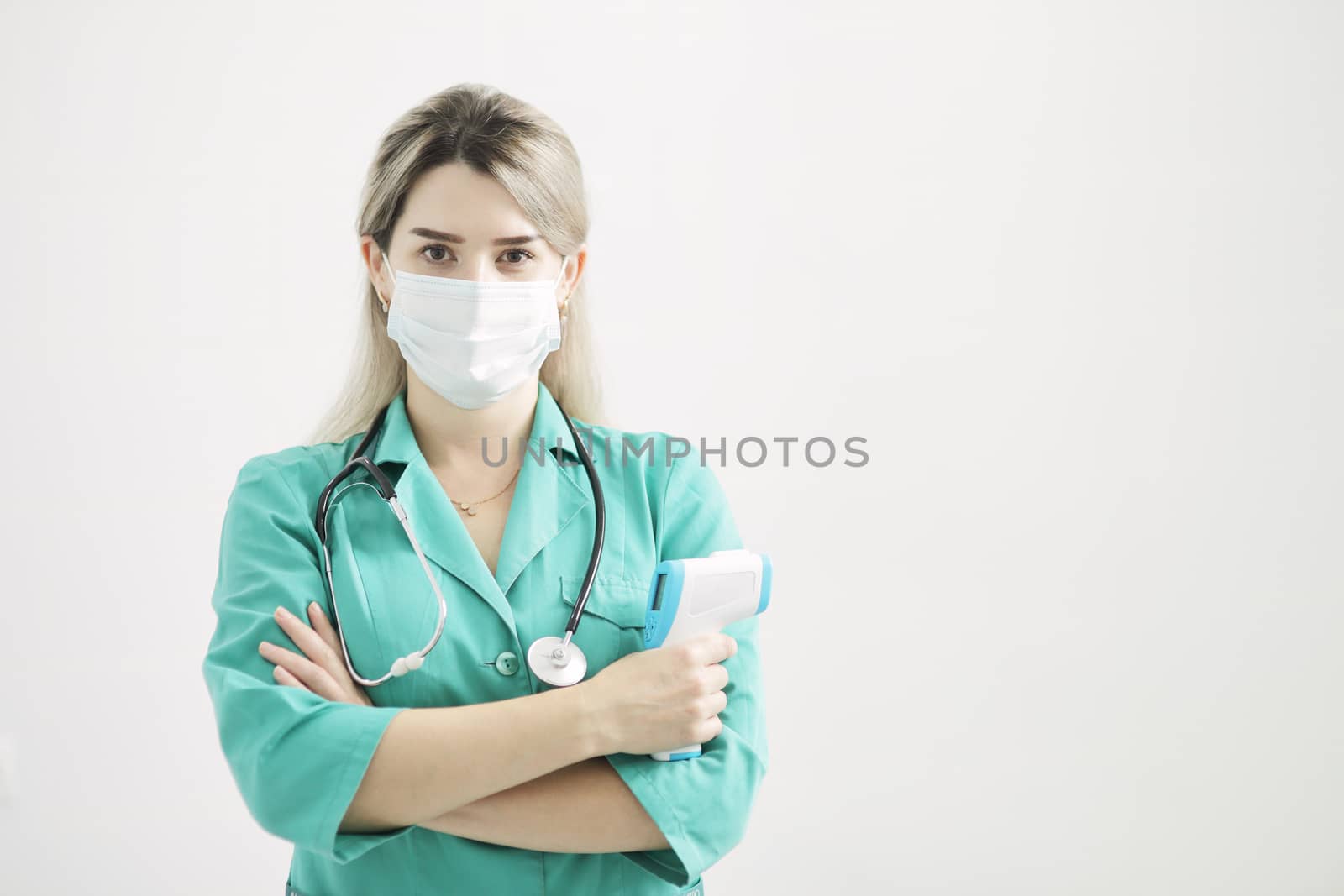 Female doctor or nurse at hospital holds pyrometer in hand by selinsmo