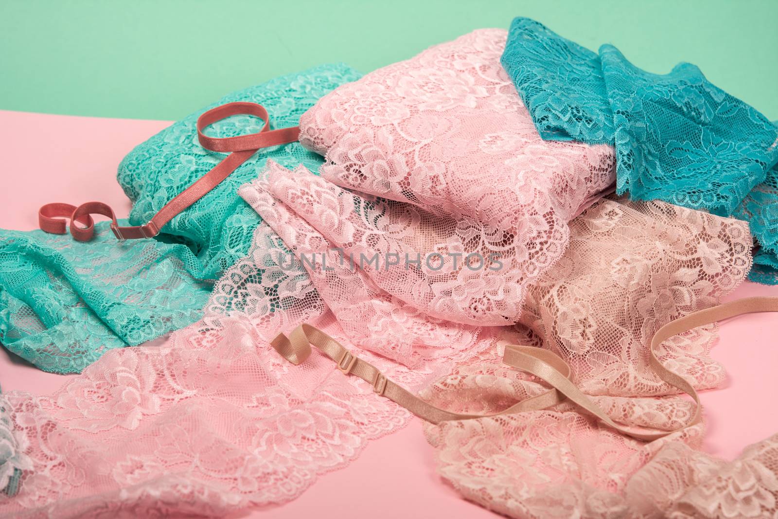 pile of color rich bright lace for Lingerie, panties, and bras on pink background by polyats