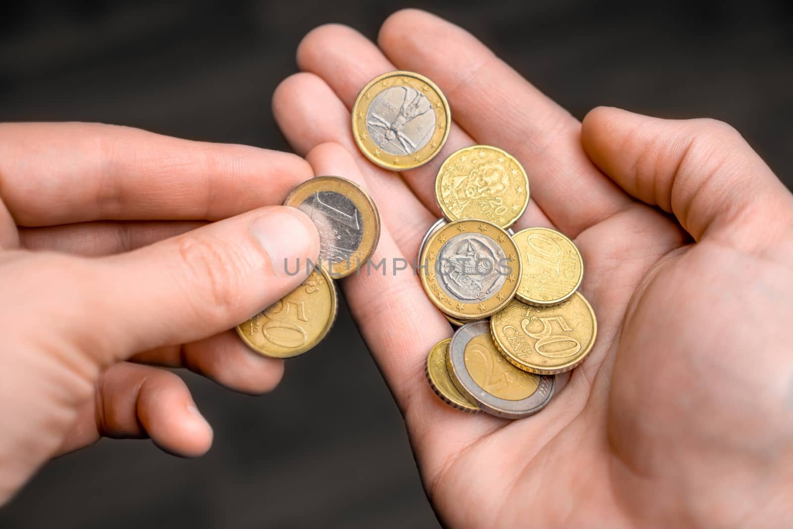 Coins in hand. Hands counting a few euro coins. A hand of coins in the palm. Economic crisis. Coins in the palm. Money in hand. Counting money, cash. Poverty concept, cash shortage. Savings. Donation by synel