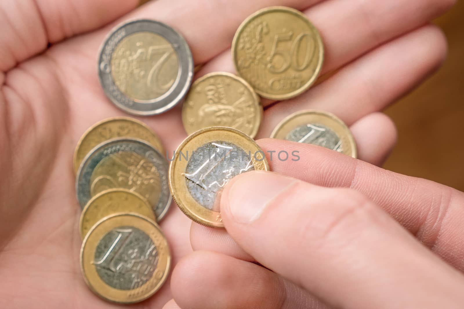 Coins in hand. Hands counting a few euro coins. A hand of coins in the palm. Economic crisis. Coins in the palm. Money in hand. Counting money, cash. Poverty concept, cash shortage. Savings. Donation