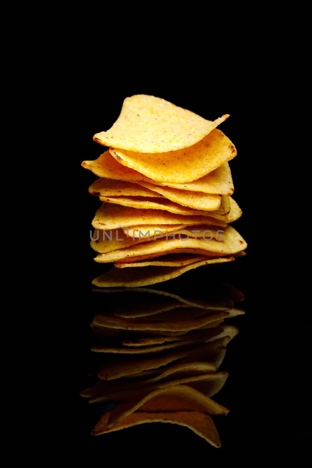 mexican nachos tortilla chips stack, black background