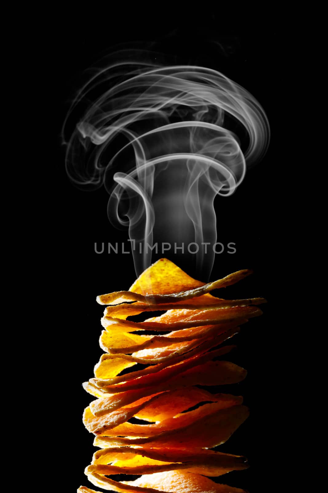 hot mexican nachos tortilla chips stack with smoke, black background
