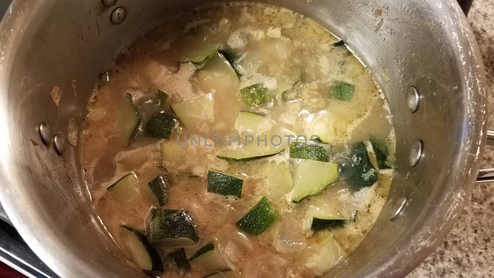 sliced zucchini cooking in metal pot of water by stockphotofan1