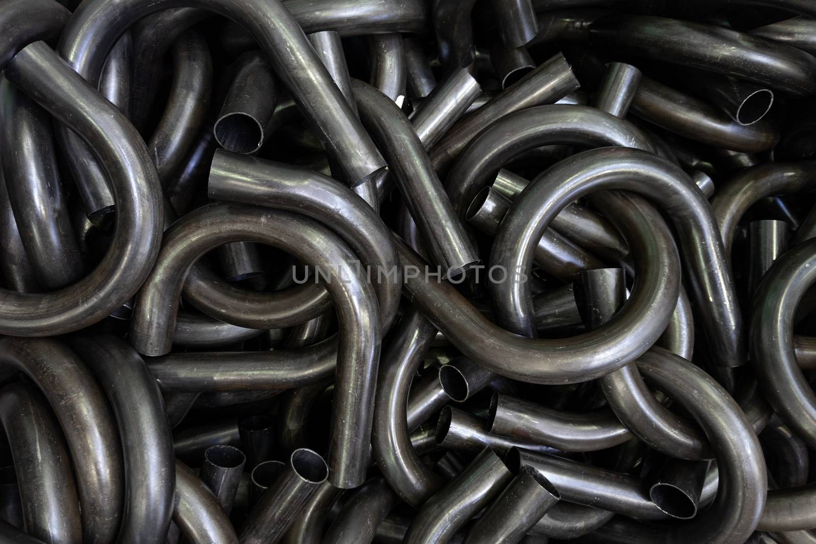 abstract black industrial full frame background of bended steel pipes.
