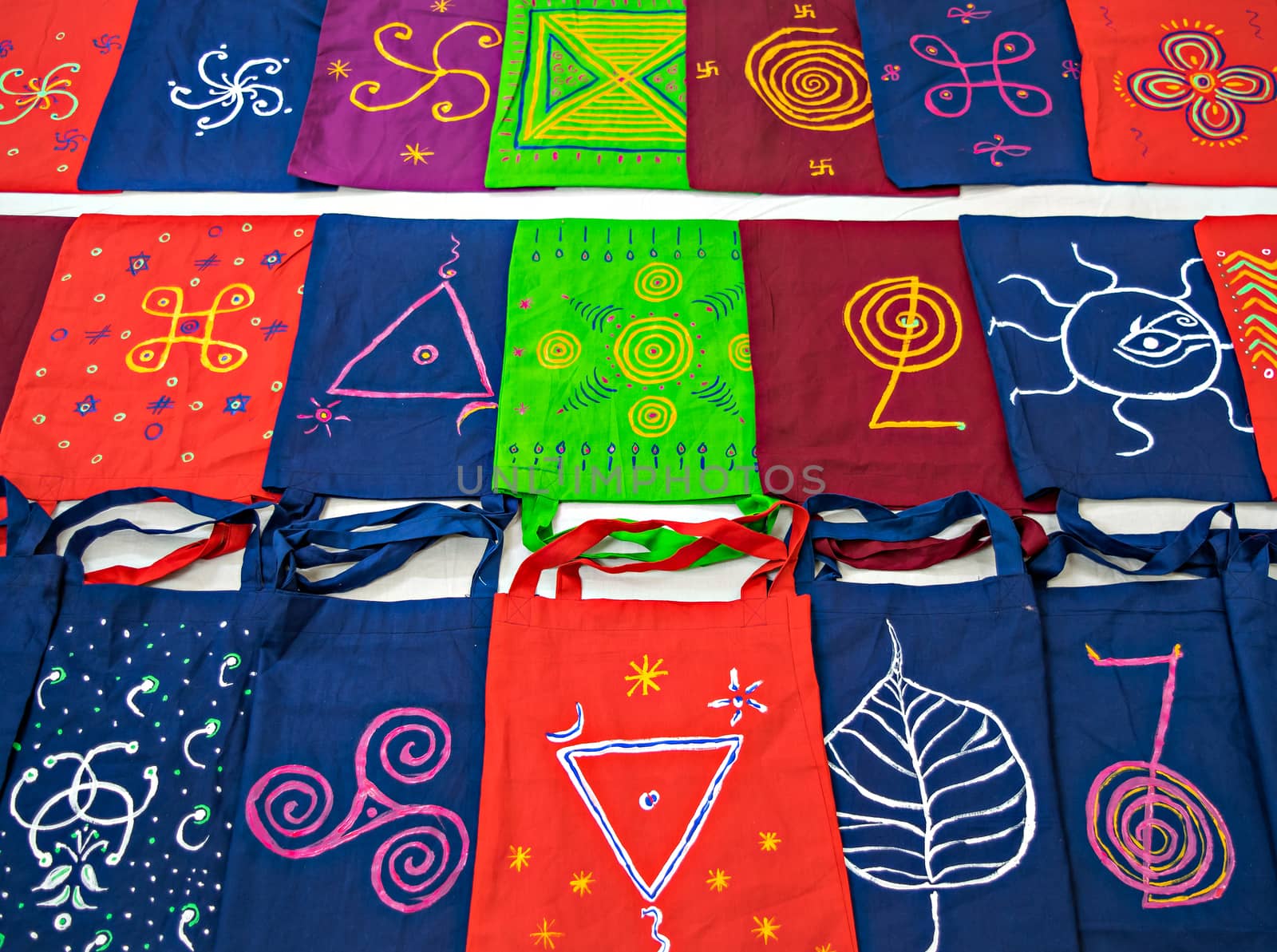 Colorful cotton bags with hand painted symbols arranged in pattern. by lalam